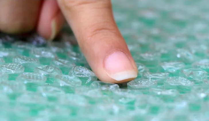 A finger popping a bubble wrap.